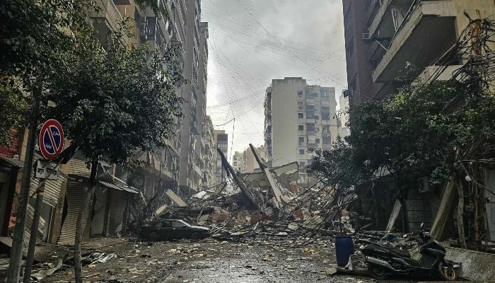 Debris from a collapsed building blocks the road at the site of an Israeli airstrike in Beiruts southern suburb Haret Hreik on March 15, 2026. — AFP
