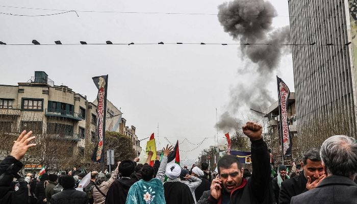 Black smoke rises after an airstrike as Iranians take part in the Al-Quds (Jerusalem) Day rally, a commemoration in support of the Palestinian people on the last Friday of the holy month of Ramadan, in Tehran on March 13, 2026. — AFP