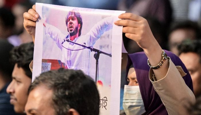 An activist holds a poster of Sharif Osman Hadi, senior leader of the student protest group Inqilab Mancha, who was shot outside a mosque, during a demonstration to condemn the attack in Dhaka on December 15, 2025. — AFP