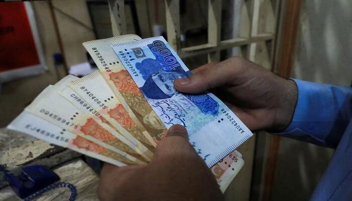 This representational image shows a man counts currency notes at a shop in Peshawar, September 12, 2023. — Reuters