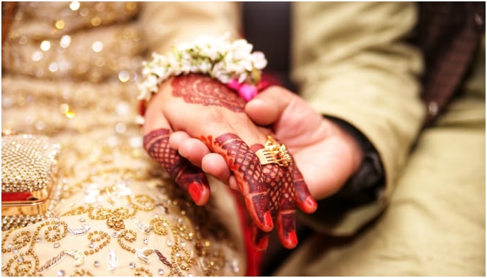 A representational image of a bride and groom holding hands. — Unsplash/File