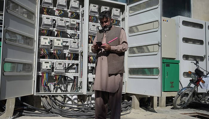 IESCO employee takes a meter reading with his smartphone at a commercial building in Islamabad on November 7, 2018. — AFP
