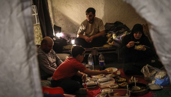 In Lebanon Near the tent woman dropped pieces of marinated chicken into a pan sizzling atop a camping stove.— Reuters