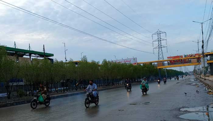 Commuters pictured on a road in Karachi after rain on March 21, 2026. — Geo.tv