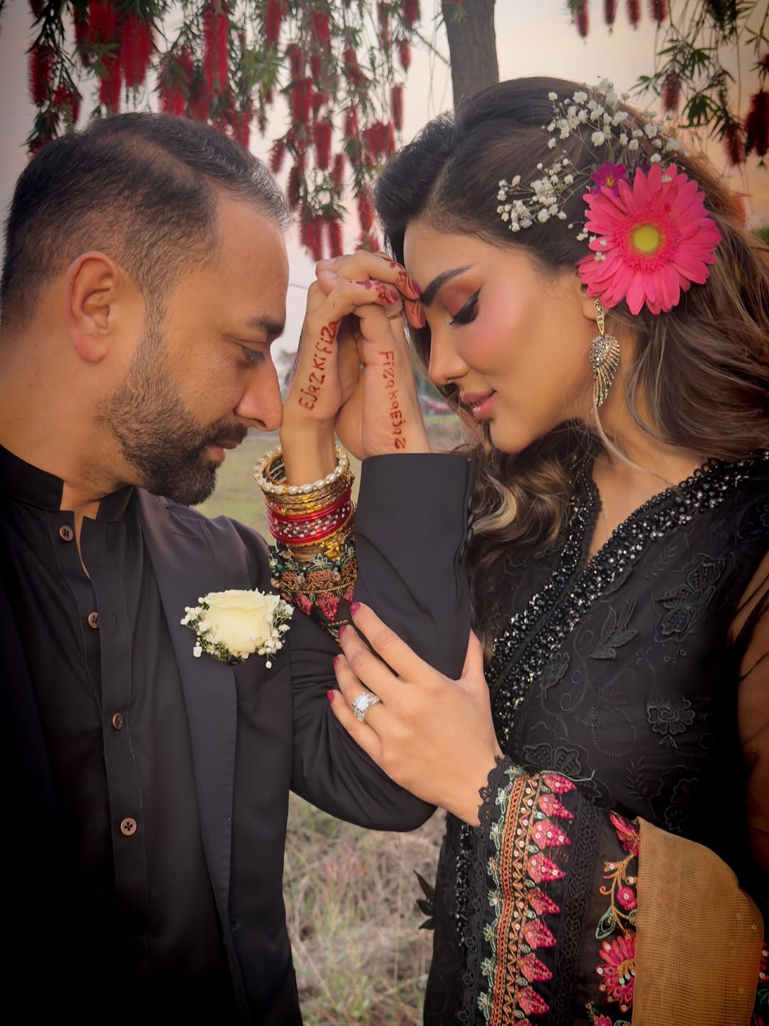 Actor Fiza Ali and her husband Ejaz Khan pose in a picture, showing their names printed with henna on each others hands. — Instagram/@Fizaali