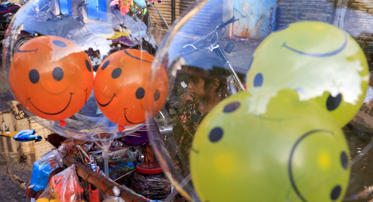 Eight-year-old Ganga, whose family moved to Karachi from Pakistans southeastern desert area of Tharparkar to look for work, waits for customers while selling balloons, as Muslims attend Eid ul Fitr prayers to mark the end of the fasting month of Ramadan, outside a mosque in Karachi, Pakistan, March 21, 2026. — Reuters