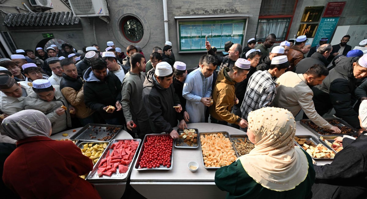 Muslim devotees eat food during Eid ul Fitr celebrations, which marks the end of the Islamic holy fasting month of Ramadan, at a mosque in Beijing on March 21, 2026. — AFP