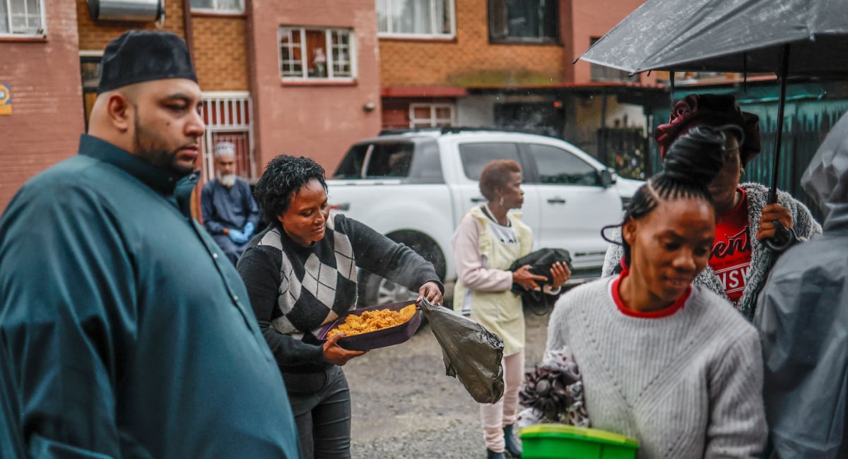 Residents of the Fietas district in Johannesburg receive hot meals during a charity drive organised by the Muslim Ziaee Institute South Africa (ZISA) on the occasion of the Eid ul Fitr at the end of the Muslim fasting month of Ramadan, on March 21, 2026. — AFP