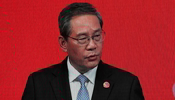 Chinese Premier Li Qiang on a big screen live broadcasting his speech at the opening of the China Development Forum 2026 held at the Diaoyutai State Guesthouse in Beijing, China, March 22, 2026. — Reuters