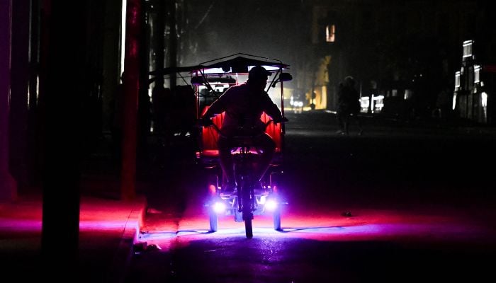 A man rides his bike during a nation wide blackout in Havana on March 21, 2026. — AFP