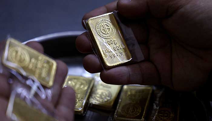 An Egyptian jeweller holds a gold bar during an interview with Reuters in Cairo, Egypt, March 9, 2026. — Reuters