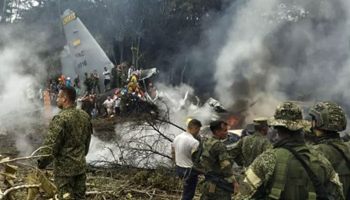 Military personnel clambered over the wreckage of the Hercules transport plane, enveloped in smoke. — AFP/File