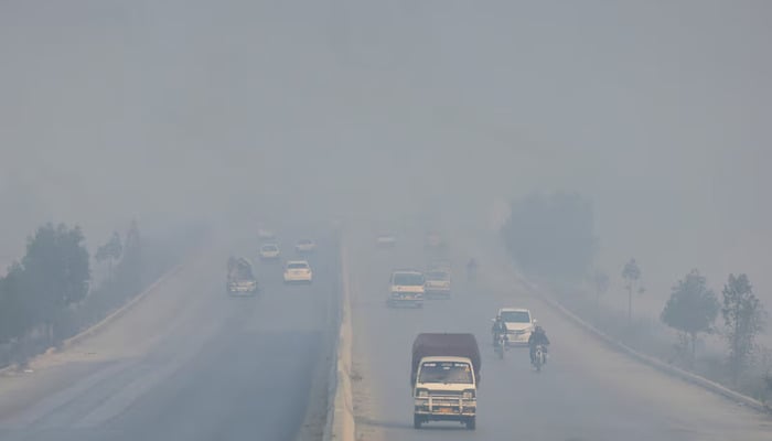 Vehicles move amid smog and air pollution during morning hours in Peshawar, Pakistan, November 28, 2025. — AFP