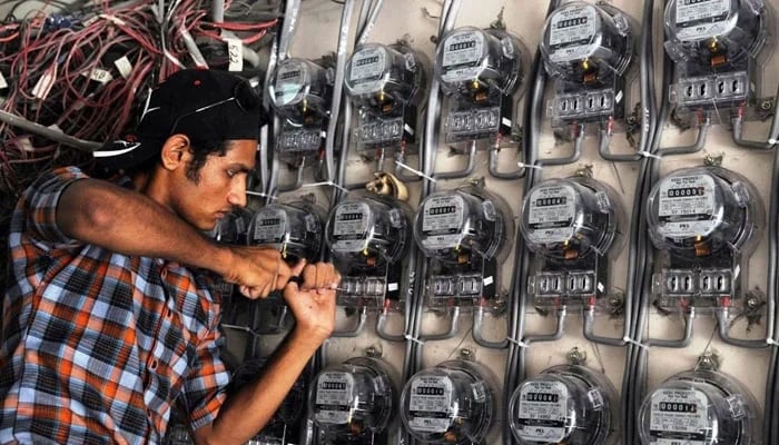 A power technician is fixing electric meters in Pakistan. — AFP/File