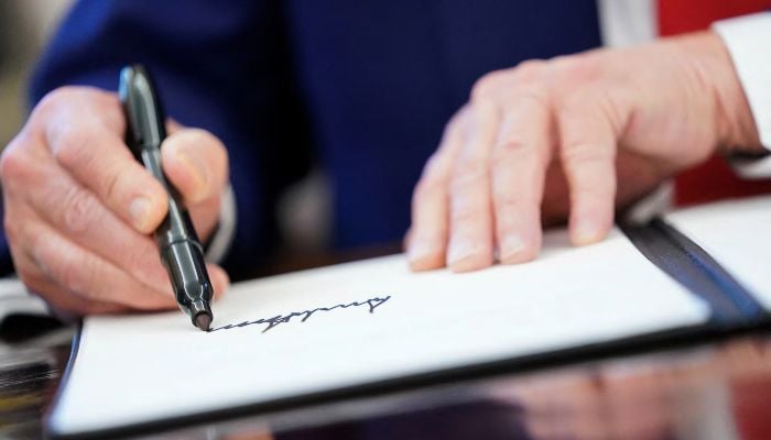 US President Donald Trump writes his signature, as he signs executive orders and proclamations in the Oval Office at the White House in Washington, DC, US, April 9, 2025. — Reuters