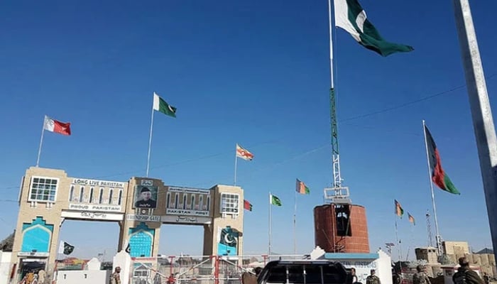 Pakistan security personnel look on as travellers wait to cross the border between Pakistan and Afghanistan at Chaman. — AFP/File