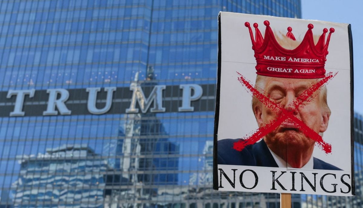 A person holds a sign with an image depicting U.S. President Donald Trump as demonstrators walk past the Trump Tower, Chicago, Illinois, US. — Reuters
