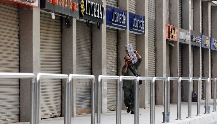 A man walks past closed market during a partial lockdown after Sindh provincial government decided to impose a lockdown in Karachi, July 30, 2021. — Reuters