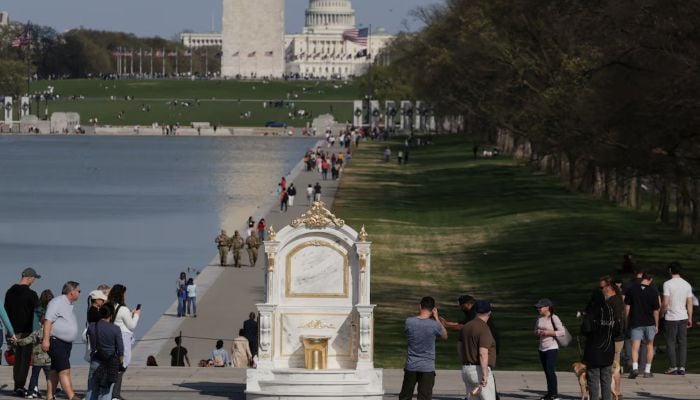 A statue featuring a large golden toilet, titled A Throne Fit for a King, is displayed near the Lincoln Memorial on the National Mall in Washington, DC, US, March 30, 2026. — Reuters
