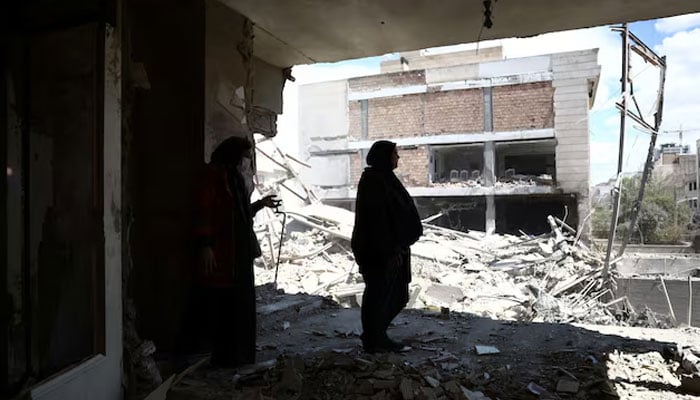 A woman stands in her brothers home, which was damaged by a strike, as the US-Israeli conflict with Iran continues, in Tehran, Iran, March 30, 2026. — Reuters