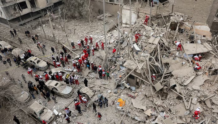 Emergency personnel work at the site of a strike on a residential building, amid the U.S.-Israeli conflict with Iran, in Tehran, Iran, March 16, 2026. — Reuters