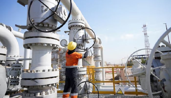 A worker operates valves at the Rumaila oil field, as the country cuts nearly 1.5 million barrels per day of output amid halted exports following the closure of the Strait of Hormuz, in Basra, Iraq, March 4, 2026.— Reuters