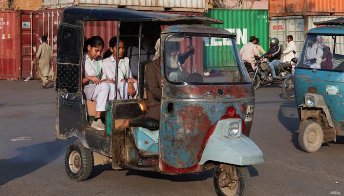 Students ride on a rickshaw while heading to school, as the government announced that schools would close for two weeks in Karachi, March 10, 2026. — Reuters
