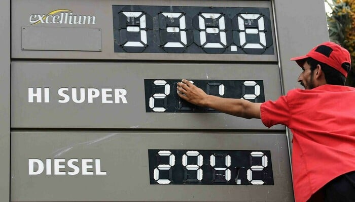 An file representational photo of a fuel station  employee updating the price board in Karachi. — AFP/File