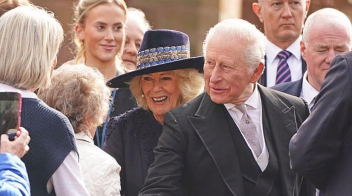 King Charles checks homework during walkabout: 'Don't get too much'