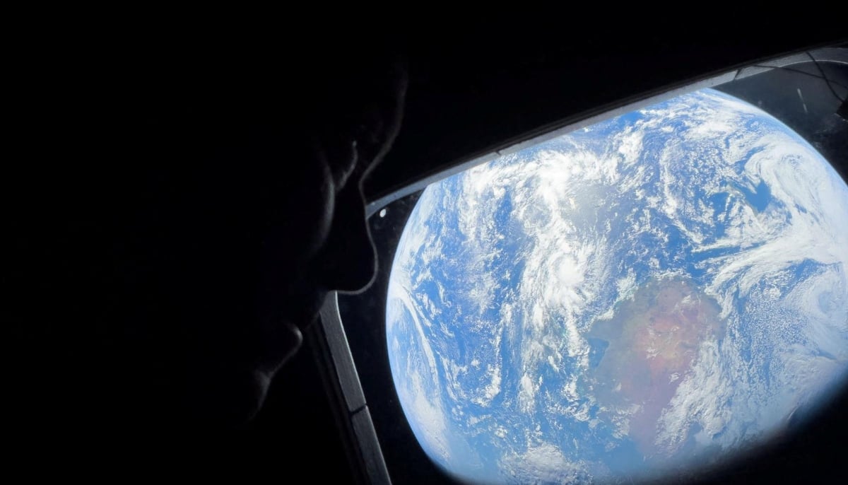 Nasa astronaut and Artemis II Commander Reid Wiseman peers out of one of the Orion spacecrafts main cabin windows, looking back at Earth, as the crew travels towards the moon April 2, 2024. — Reuters