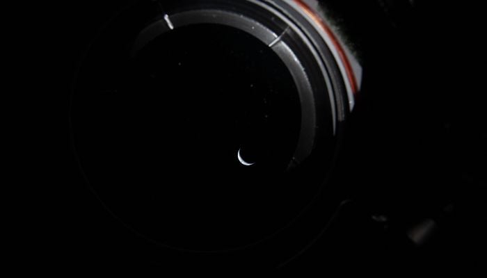 This handout picture by an Artemis II crew member provided by Nasa shows a sliver of the Earth illuminated by the blackness of space peering out the window of the Orion spacecraft on April 3, 2026. — AFP
