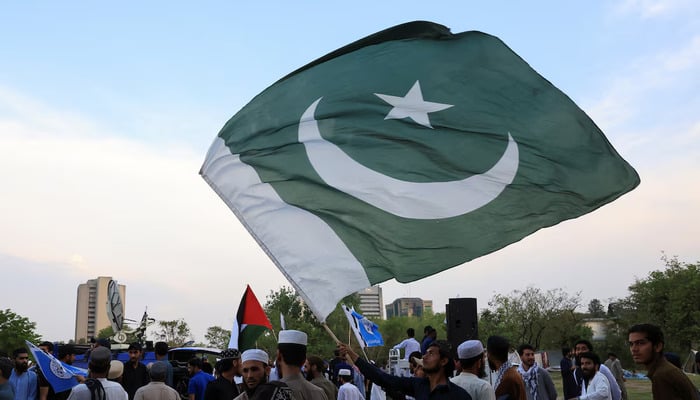 A man waves Pakistans flag as he along with others gather in support of Pakistan Army, day after the ceasefire announcement between India and Pakistan, in Islamabad, May 11, 2025. — Reuters