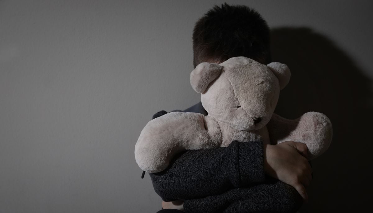 A representational image shows a child hiding behind a stuffed toy. — Canva