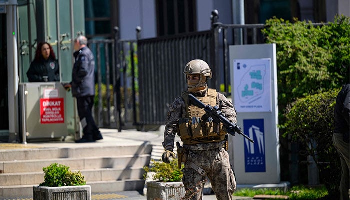 A police official stands alert near the Israeli consulate in Istanbul on April 7, 2026, following a shootout between gunmen and police. — AFP