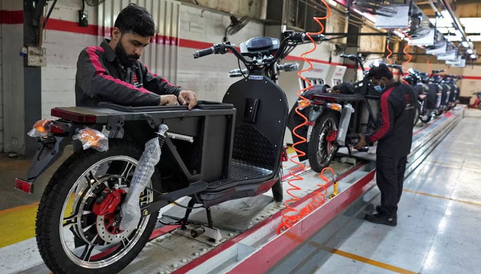 Workers assemble parts of electric motorcycles on the production line at the ZYP Technologys facility in Lahore, Pakistan, March 12, 2025. — Reuters