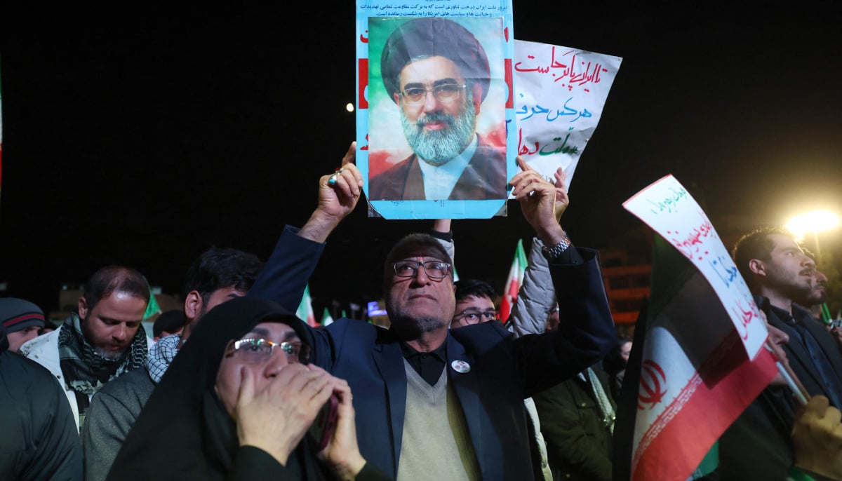 An Iranian man holds up picture of Iranian supreme leader Ayatollah Mojataba Khamenei as others react to a ceasefire announcement at the Enqelab square, in Tehran, on April 8 2026. — AFP
