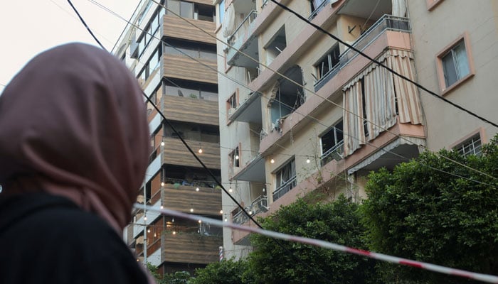 A woman looks at the site of an Israeli strike, which hit an apartment and caused minor damages to buildings around, in Al Manara area in Beirut, Lebanon, April 8, 2026. — Reuters