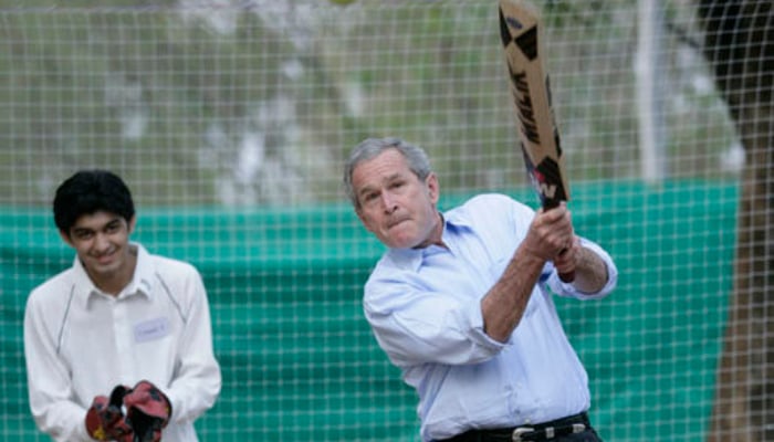 President George W Bush watches his hit during a cricket clinic with Pakistani youth from the Schola Nova school and the Islamabad College for Boys, March 4, 2006, at the Raphel Memorial Gardens on the grounds of the US Embassy in Islamabad, Pakistan. — The White House