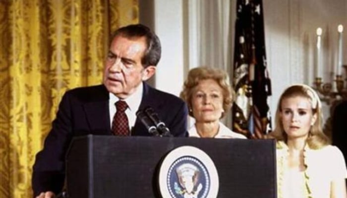 Former US President Richard Nixon (left), listened to by First Lady Pat Nixon and daughter Tricia Nixon (right), says goodbye to family and staff in the White House East Room on August 9, 1974. — Reuters