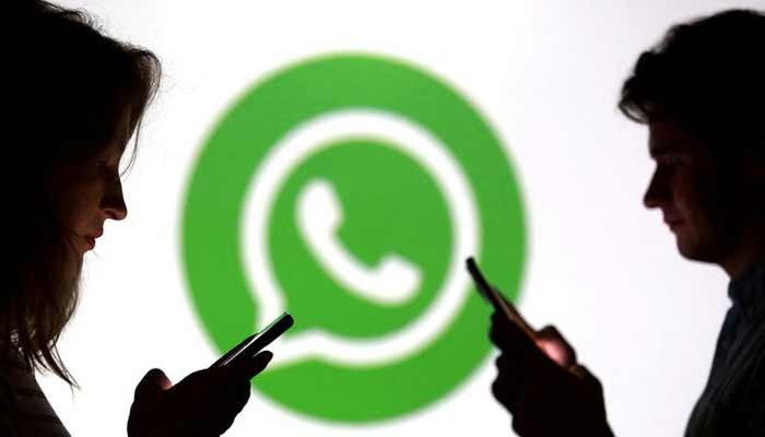 Teenagers pose for a photo while holding smartphones in front of a Whatsapp logo in this illustration taken September 11, 2025.— Reuters/File