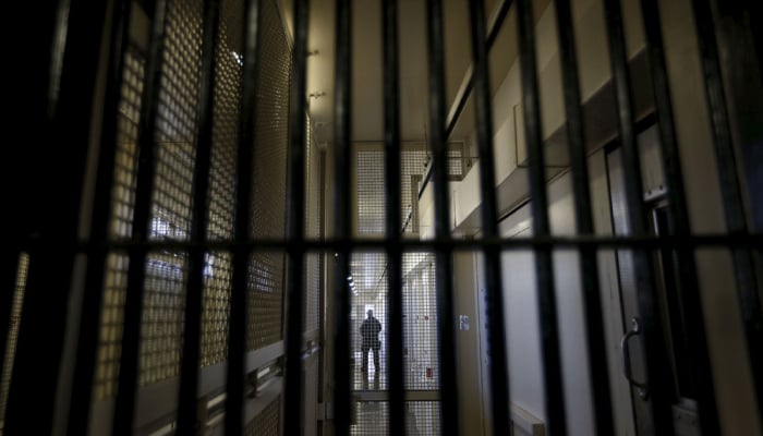 A guard stands behind prison bars at a facility. — Reuters/File