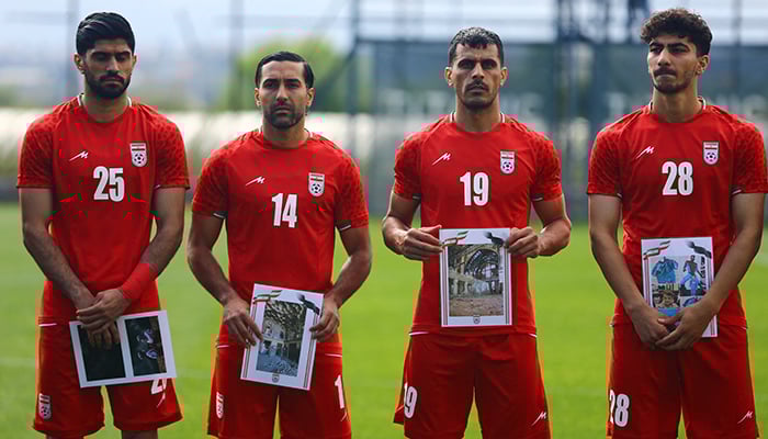 Irans Danial Esmaeilifar, Saman Ghoddos, Ali Nemati and Amirmohammad Razzaghinia hold pictures of damaged buildings and young victims as they line up before the match against Costa Rica, at Mardan Sports Complex, Antalya, Turkiye, March 31, 2026. — Reuters
