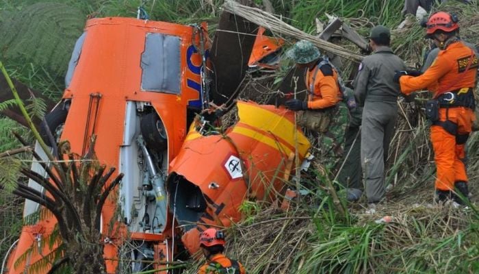 Members of an Indonesian search and rescue team examine the wreckage of a team helicopter on July 4, 2017, after it crashed in Temanggung, central Java. — AFP