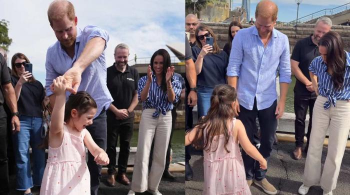 Prince Harry dances with sweet princess as Meghan slips away