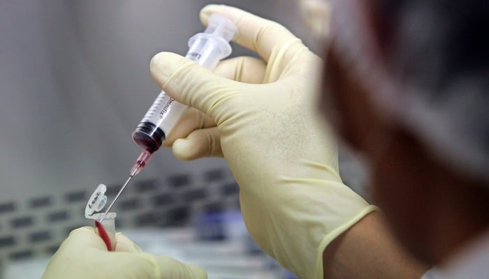 A representational image of a laboratory worker filling a test tube with a blood sample for evaluation. — Reuters