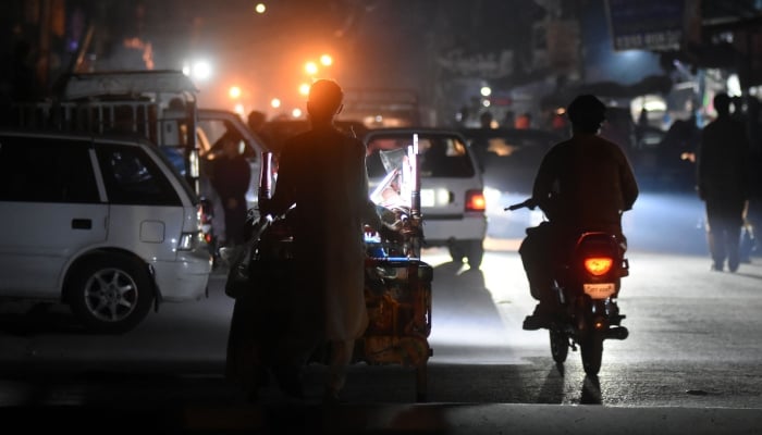 People on their way in darkness road during a power cut in Rawalpindi, April 16, 2026. — Online