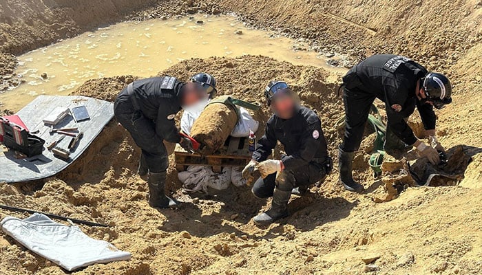 This undated handout photograph made available by the Prefecture de Police on April 19, 2026 shows members of the police Explosive ordnance disposal unit (EOD) operating to neutralise a bomb from World War II partially uncovered near a residential area, in Paris northwestern suburb of Colombes. — AFP