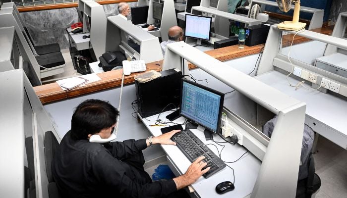 Stockbrokers monitor share prices during a trading session at the Pakistan Stock Exchange (PSX) in Karachi on April 8, 2026. — AFP