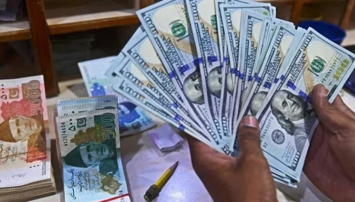 A foreign currency dealer counts US dollars at a shop in Karachi, Pakistan, May 19, 2022. — AFP/File