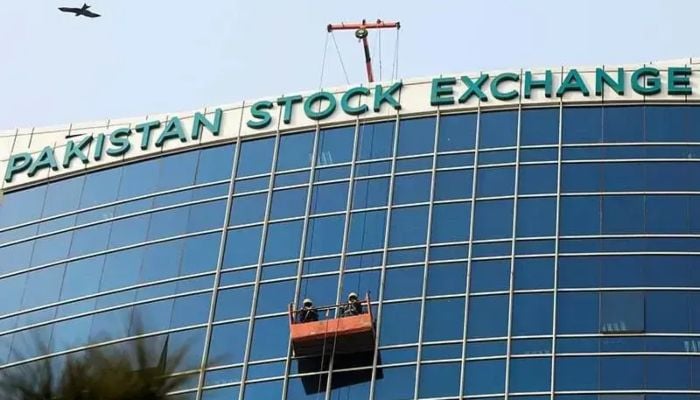 Workers clean a glass facade of the Pakistan Stock Exchange (PSX) building in Islamabad on December 3, 2018. — Reuters